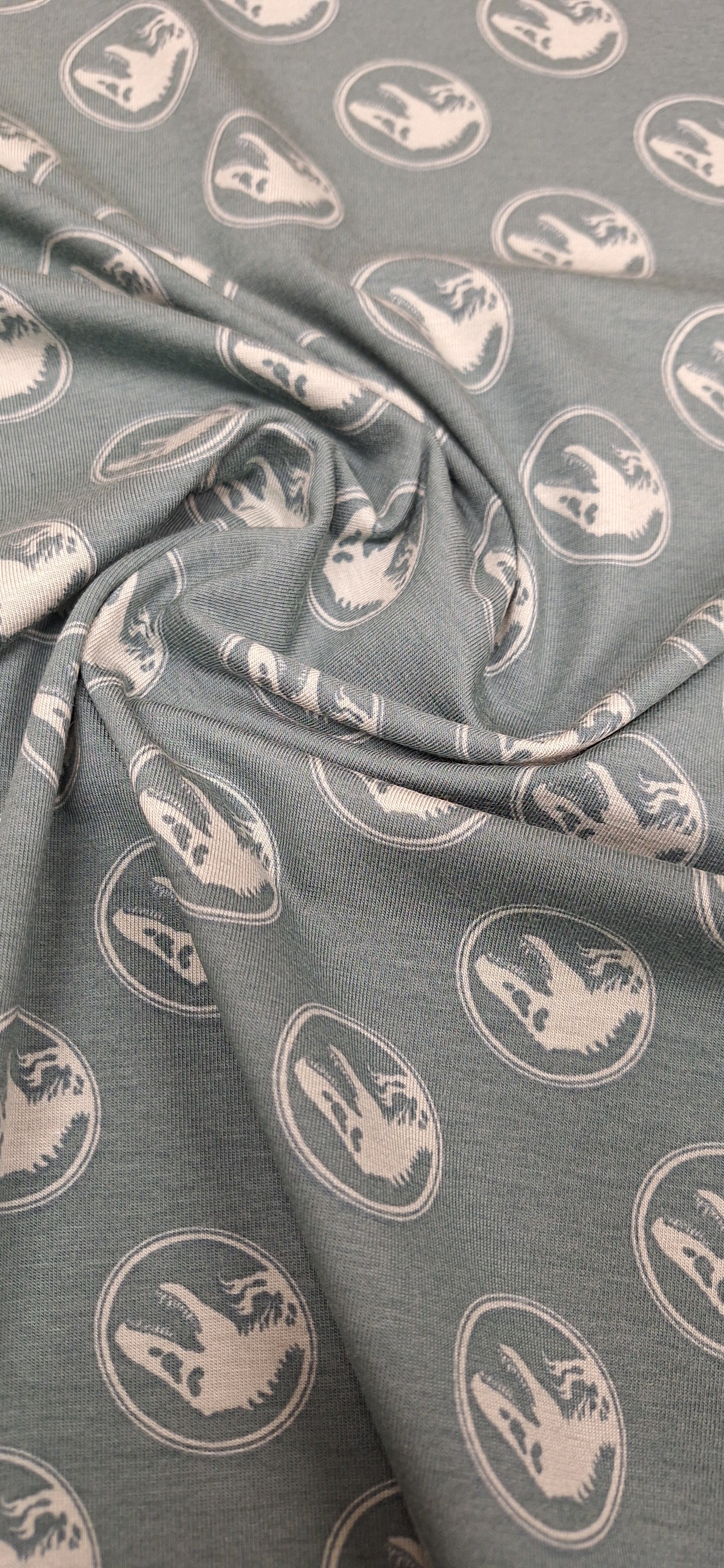 Baumwolljersey grün mit Dinosaurierköpfen