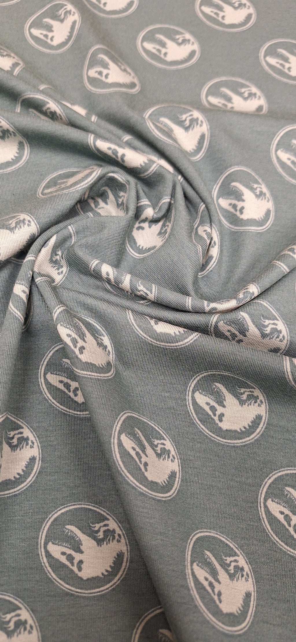 Baumwolljersey grün mit Dinosaurierköpfen