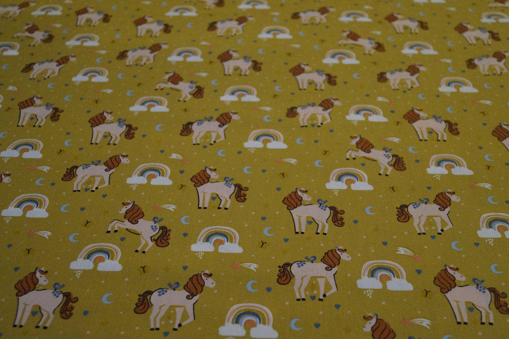 Popeline ockerfarben mit Einhörnern und Regenbogen
