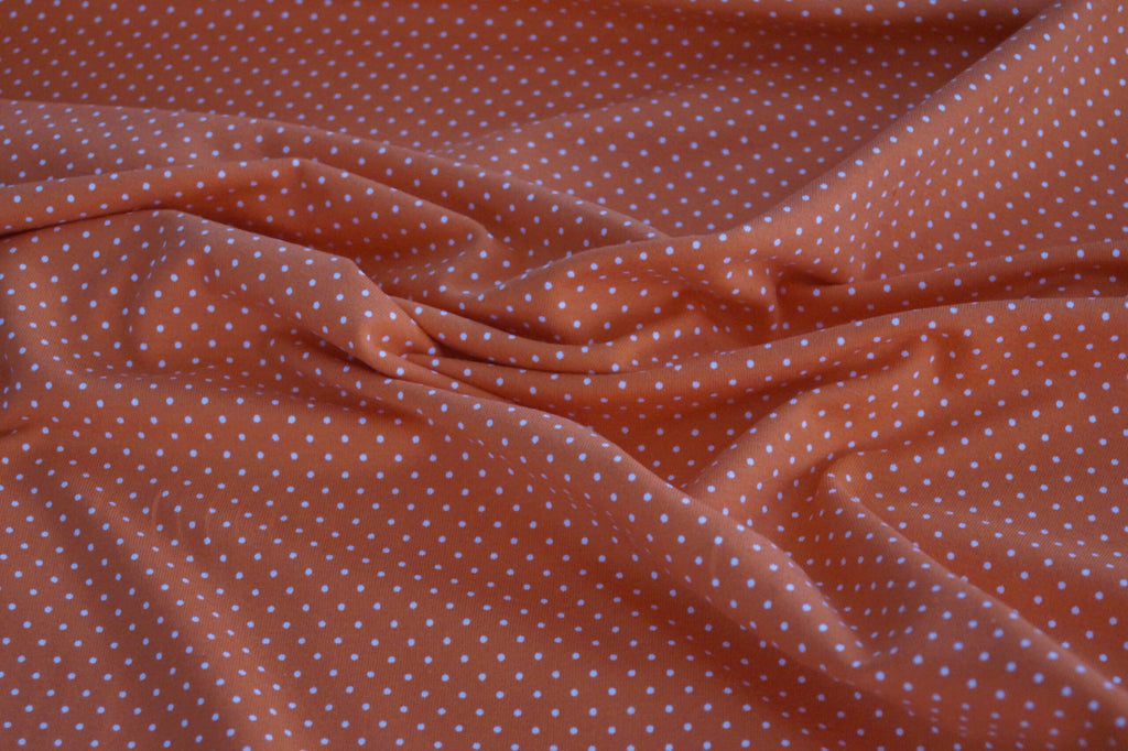 Baumwolljersey orange mit weißen Punkten