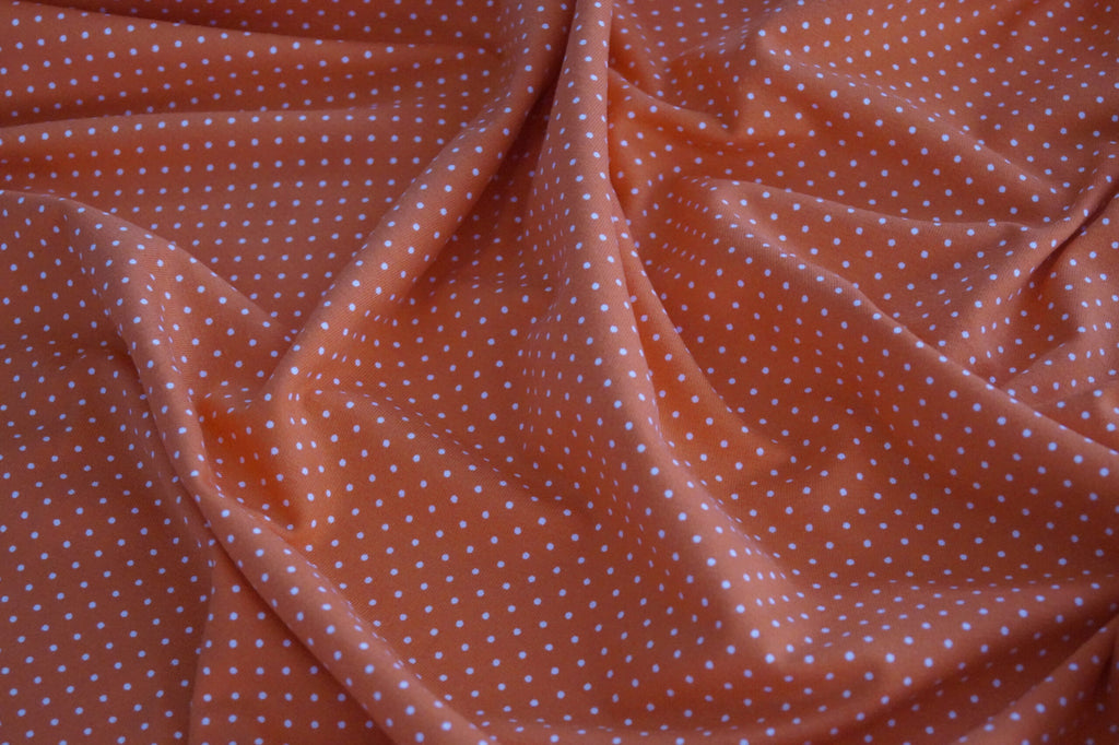 Baumwolljersey orange mit weißen Punkten
