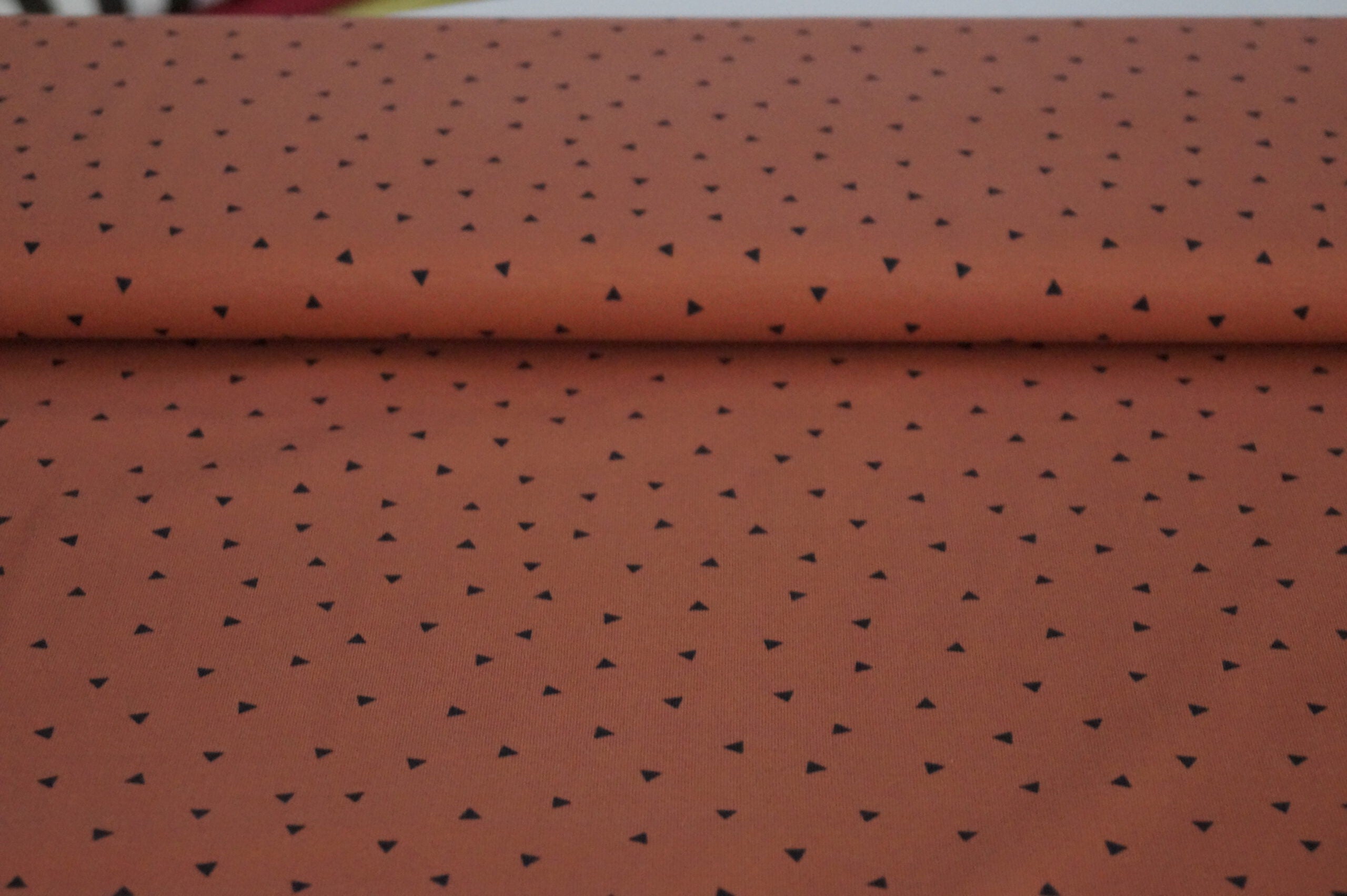 Baumwolljersey rostbraun mit kleinen schwarzen Dreiecken